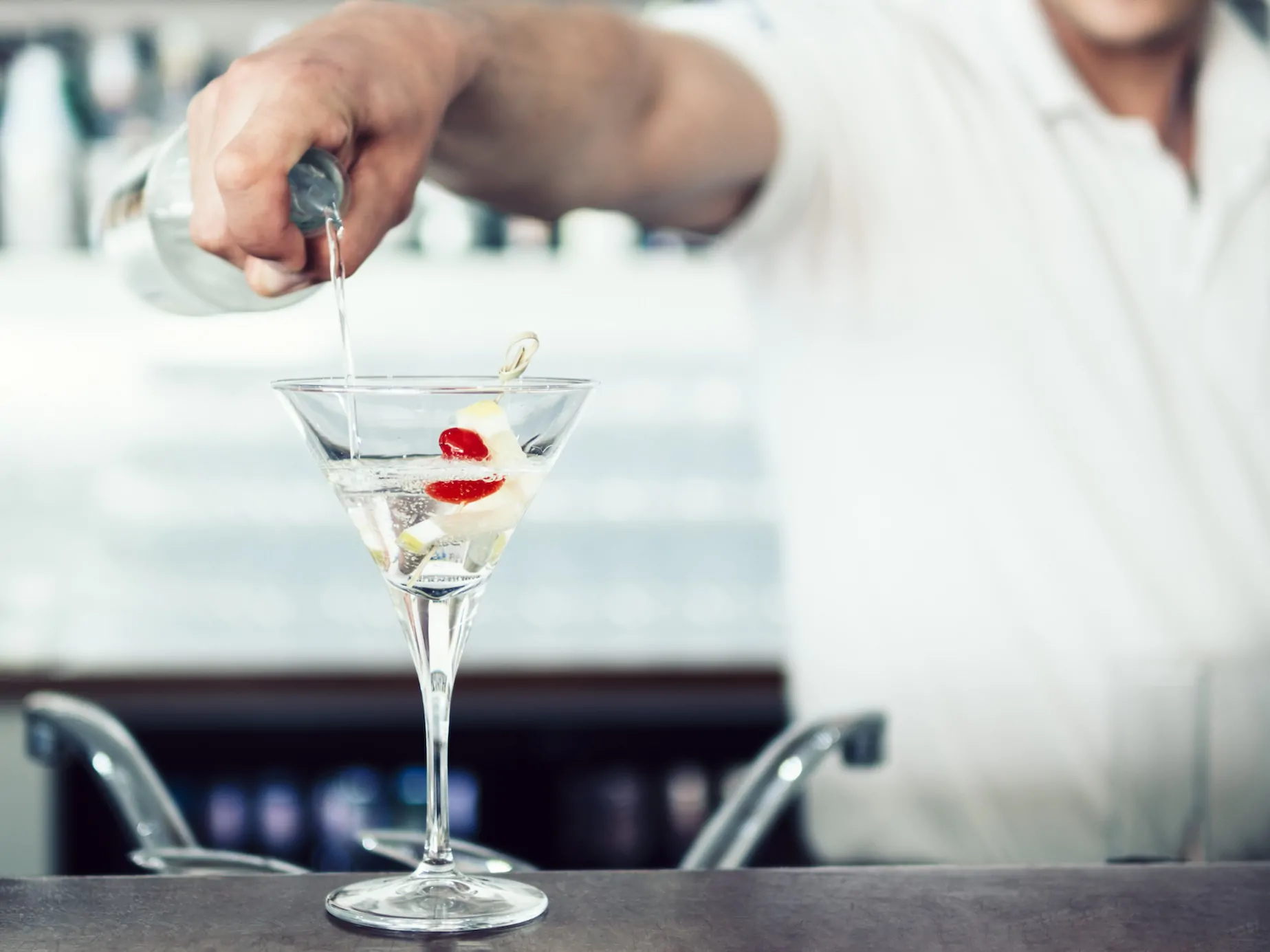 unrecognizable barman pouring cocktail glass
